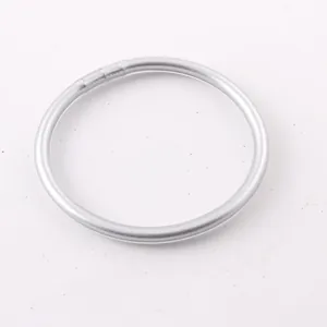 Detail view of a minimalist silver shiny silicone bangle with a sleek circular design