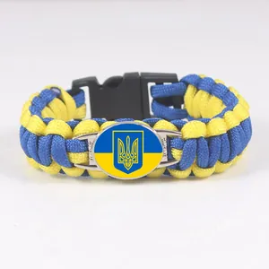Detail view of a yellow and blue paracord survival bracelet with Ukraine coat of arms
