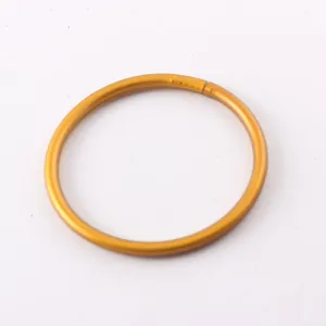 Close-up of a minimalist golden glitter silicone bangle bracelet with a smooth finish