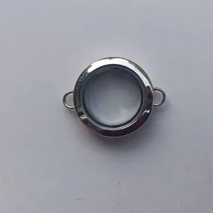 Macro view of a circular transparent silver Gau box locket with dual connection rings