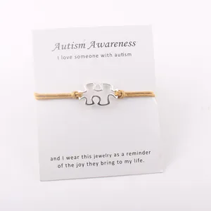 Detailweergave van zilveren puzzelarmband op een Autism Awareness-boodschap kaart cadeau