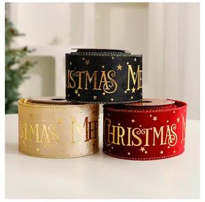 Macro detail of red, black and gold velvet Christmas ribbons with gold foil Merry Christmas text.