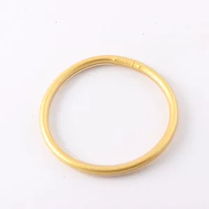 Detailed macro view of a flexible shiny gold foil silicone bangle bracelet for women.