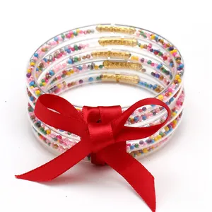 Set di braccialetti in silicone a 5 strati con un festoso fiocco di nastro di raso rosso
