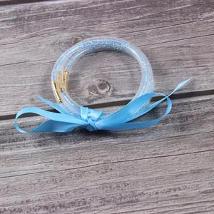Primer plano de brazaletes de gelatina con diamantes azules y lazo de satén