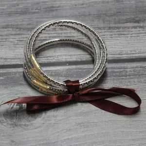 Primer plano de una pulsera de cinco capas de silicona con cuentas y un lazo de raso marrón