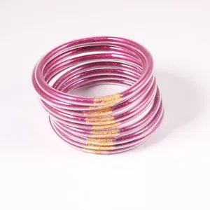 Detail view of a 12-piece set of purple glitter jelly bangles in soft PVC material
