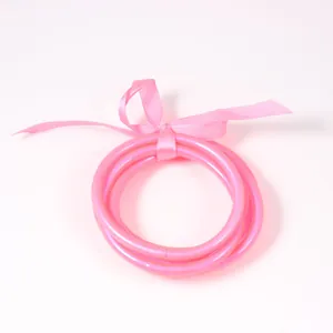 Vibrant pink PVC silicone jelly bangles 3-piece set with a decorative pink ribbon bow