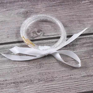 Detalle de tres pulseras de silicona con diamantes de imitación y cinta blanca pura