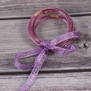 Detail van paarse glitter siliconen armbanden set met sprankelende lint strik