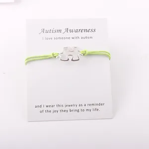 Detail van de Autism Awareness armband met zilveren puzzelstukje en groen koord