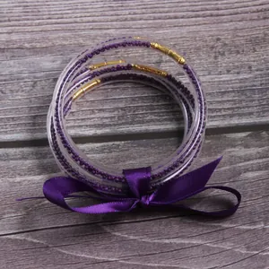 Set of 5 purple seed bead silicone jelly bangles decorated with a satin ribbon bow