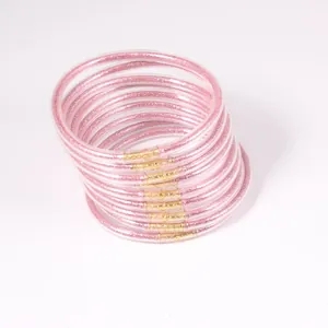Detail of 12 pink glitter jelly bangles stacked together with gold-colored connectors