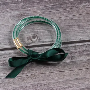 Vista detallada de pulseras jelly de 3 capas con pedrería verde y lazo de cinta