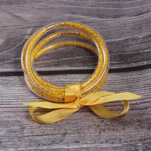 5-piece set of yellow seed bead silicone jelly bangles with decorative ribbon bow