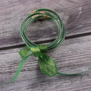 Macrodetail van vijf groene siliconen glitterarmbanden met een feestelijke strik