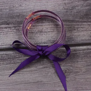 Vue rapprochée de trois joncs à paillettes violettes avec un nœud en ruban de soie