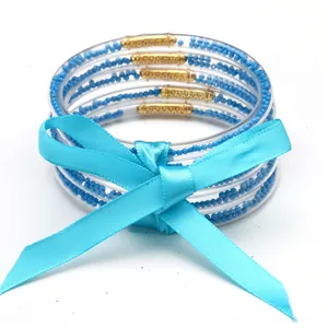 Vista dettagliata di un set di cinque braccialetti jelly con perline blu e fiocco
