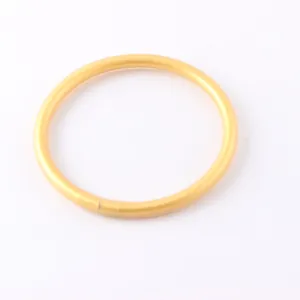 Close-up of a matte gold silicone circular bracelet with a smooth seamless finish