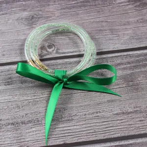 Vista detallada de pulseras de gelatina verde claro de tres capas con lazo de cinta de seda