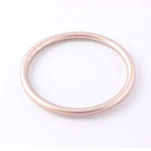 Detailed view of a matte rose gold silicone bracelet with smooth circular design.