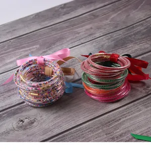 Colorful silicone jelly bangles with seed beads and festive ribbon bows for women.