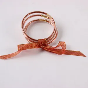 Set van 5 met glitter gevulde siliconen jelly-armbanden met een elegante rode strik