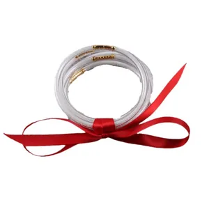 Set of five glittery white silicone All Weather Jelly Bangles tied with a red ribbon