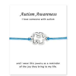 Bracelet bleu de sensibilisation à l'autisme avec breloque puzzle argentée sur carte
