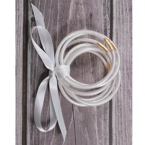 Set of 7 sparkling silicone jelly bangles with white glitter and decorative satin ribbon bow.