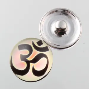 Detailed macro view of an 18mm Noosa snap button featuring a spiritual Om symbol.