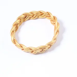 Gros plan d'un bracelet torsadé en PVC doré à 6 brins tressés sur un fond blanc épuré