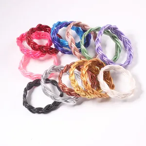 Détail de bracelets torsadés en PVC tressé coloré dans diverses finitions métalliques.