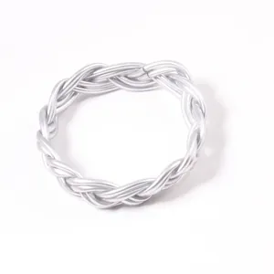 Vue rapprochée d'un bracelet en PVC tressé argenté montrant la texture torsadée
