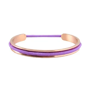 Close-up of rose gold hair tie bracelet featuring a purple elastic band in the groove