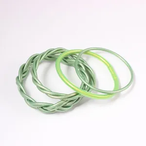 Close-up detail of a 4-piece set of green braided jelly bangles with gold foil and glitter.