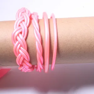 Close-up detail of pink PVC silicone braided jelly bangles four-piece set on a prop