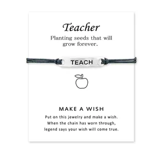 Dettaglio del bracciale dei desideri per insegnante con piastra TEACH sulla carta.