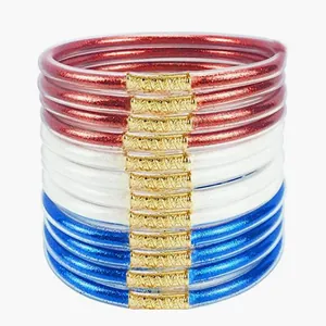 Set of 12 glitter jelly bangles in red, white and blue with textured gold connectors