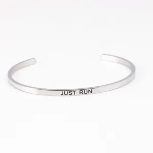 Detailed close-up view of a silver stainless steel cuff bracelet with 'JUST RUN' engraving
