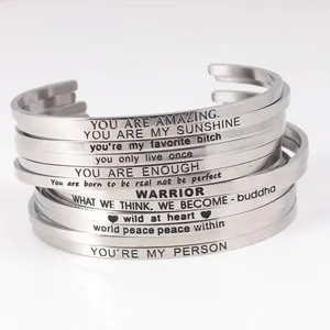 Detailed close-up of engraved inspirational phrases on stainless steel cuff bracelets