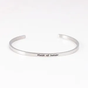 Detail of engraved 'Maid of honor' text on silver stainless steel cuff bracelet