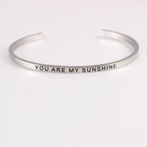 Close-up of stainless steel cuff bracelet with You Are My Sunshine engraving