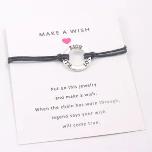 Detailed view of Faith Hope Love engraved silver ring on navy blue cord bracelet