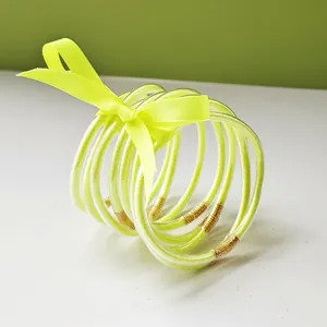 Detailed macro view of 9 pieces set of fluorescent yellow glitter jelly bangles with ribbon