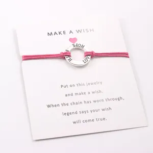 Pink wax cord bracelet with engraved 'HOPE LOVE FAITH' silver ring on wish card