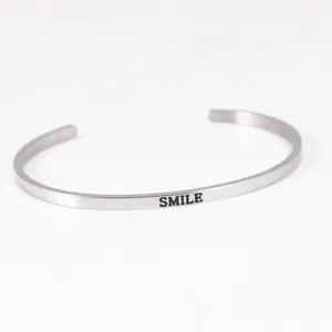 Inspirational stainless steel cuff bracelet engraved with SMILE on white background