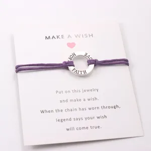 Detail shot of purple wax cord bracelet with engraved silver FAITH HOPE LOVE ring.