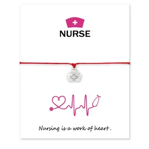 Close-up of nurse hat charm bracelet on white message card with heart quote