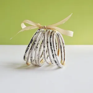 Macro view of 9-piece jelly bangle set with snake print patterns and gold accents.